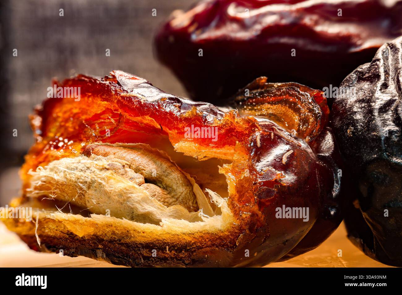 Primo piano delle date mature con un taglio aperto per mostrare il seme e la trama interna. Foto Stock