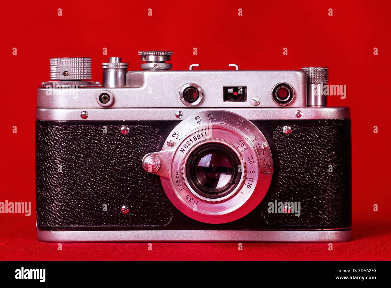 Vecchia fotocamera compatta da 35 mm su sfondo rosso, isolata. Foto Stock