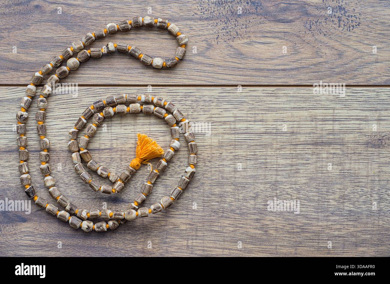 Japa Mala Beads a spirale su un tavolo di legno per la Meditazione e lo Yoga Foto Stock