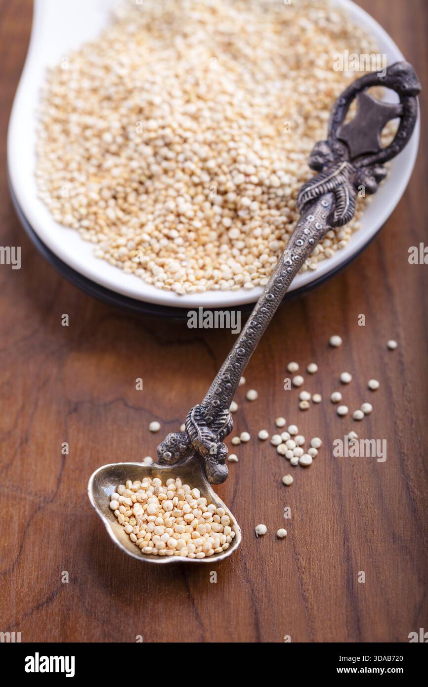 Materie di quinoa wit un cucchiaio sul tavolo di legno Foto Stock