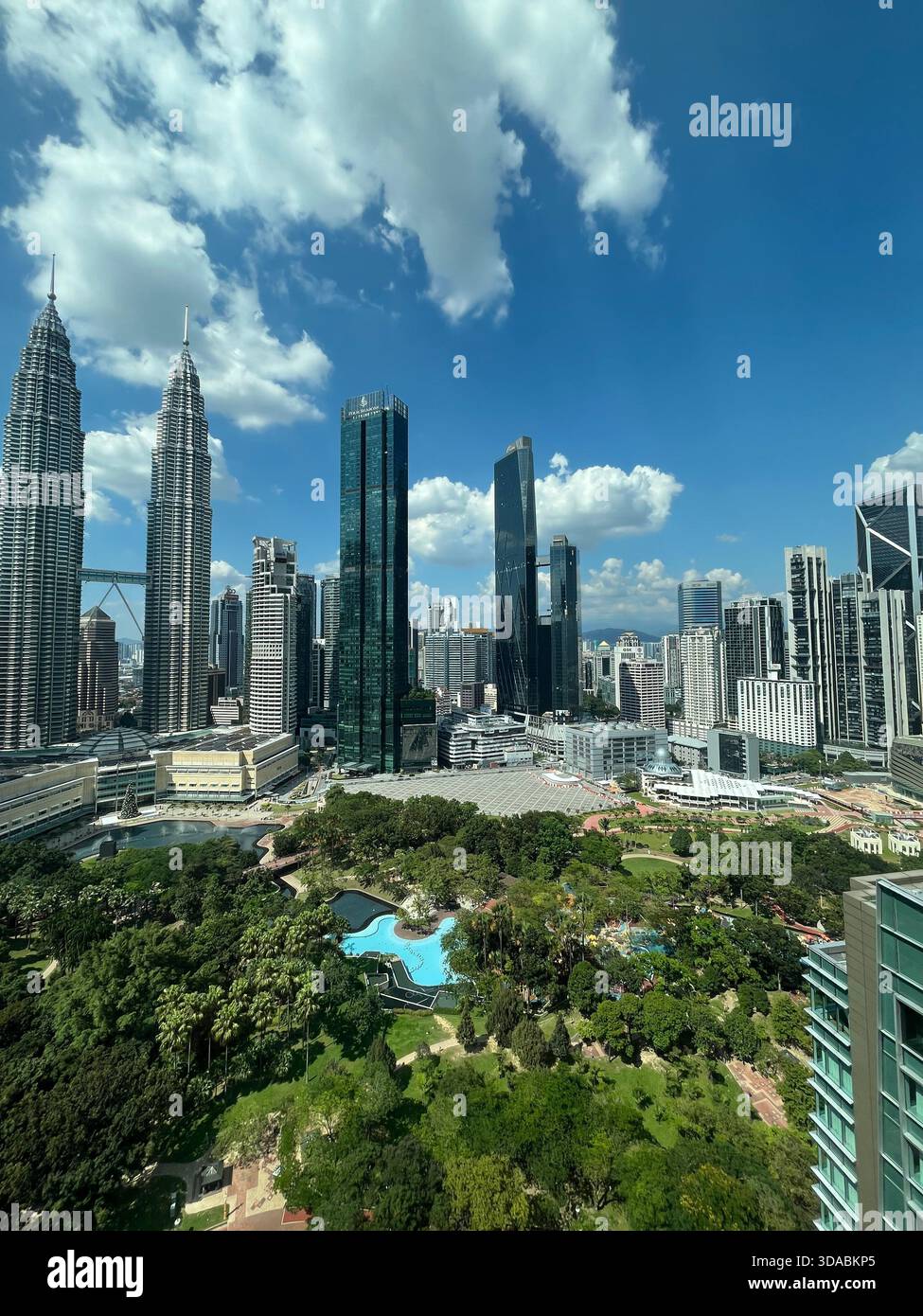 Skyline di Kuala Lumpur con le Torri Petronas che si innalzano sopra un lussureggiante parco dove la natura incontra la meraviglia architettonica. - Immagine stock catturata con smartphone