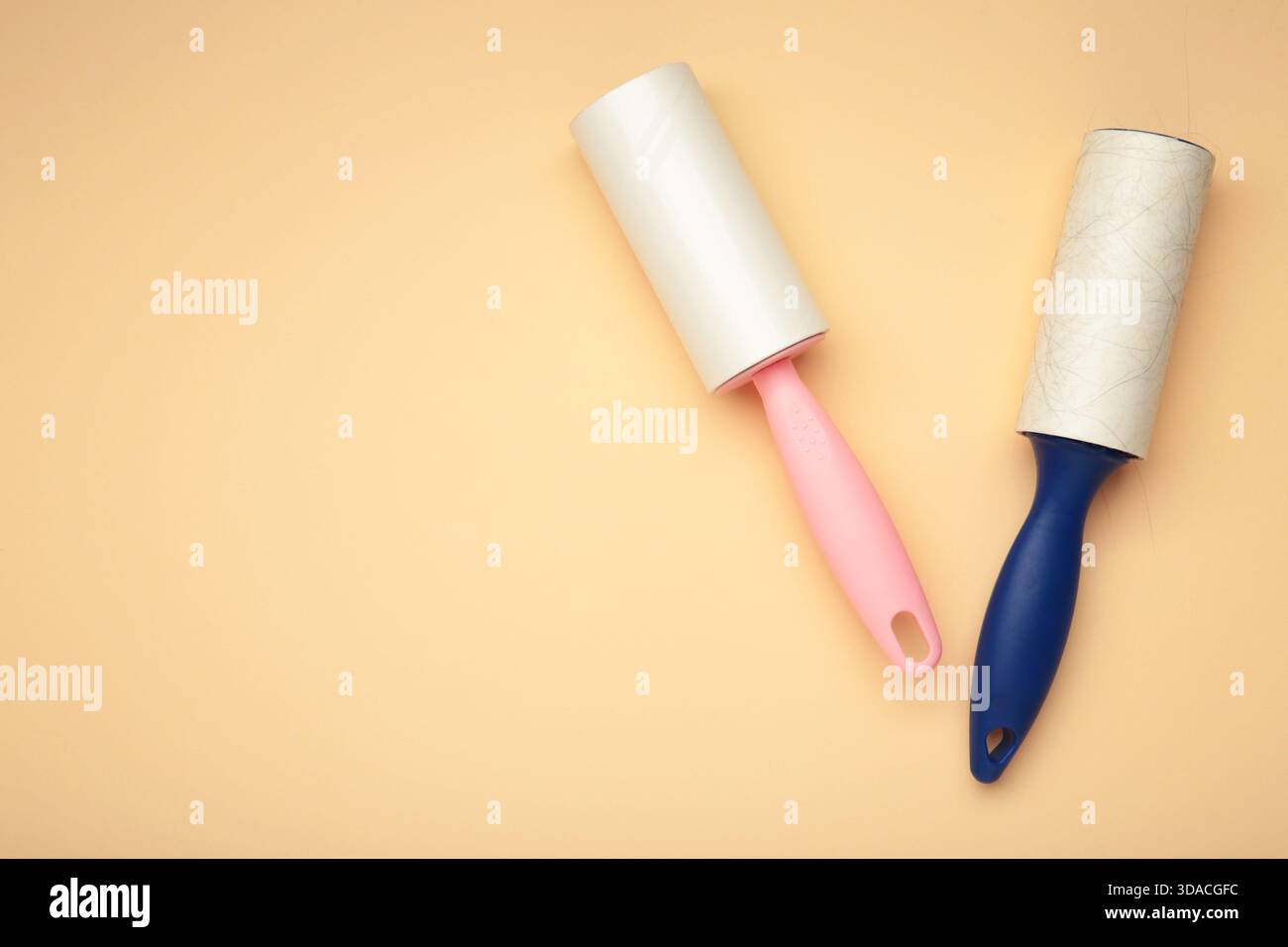 Spazzola a rullo per tessuti con carta su sfondo beige. Spazio per il testo Foto Stock