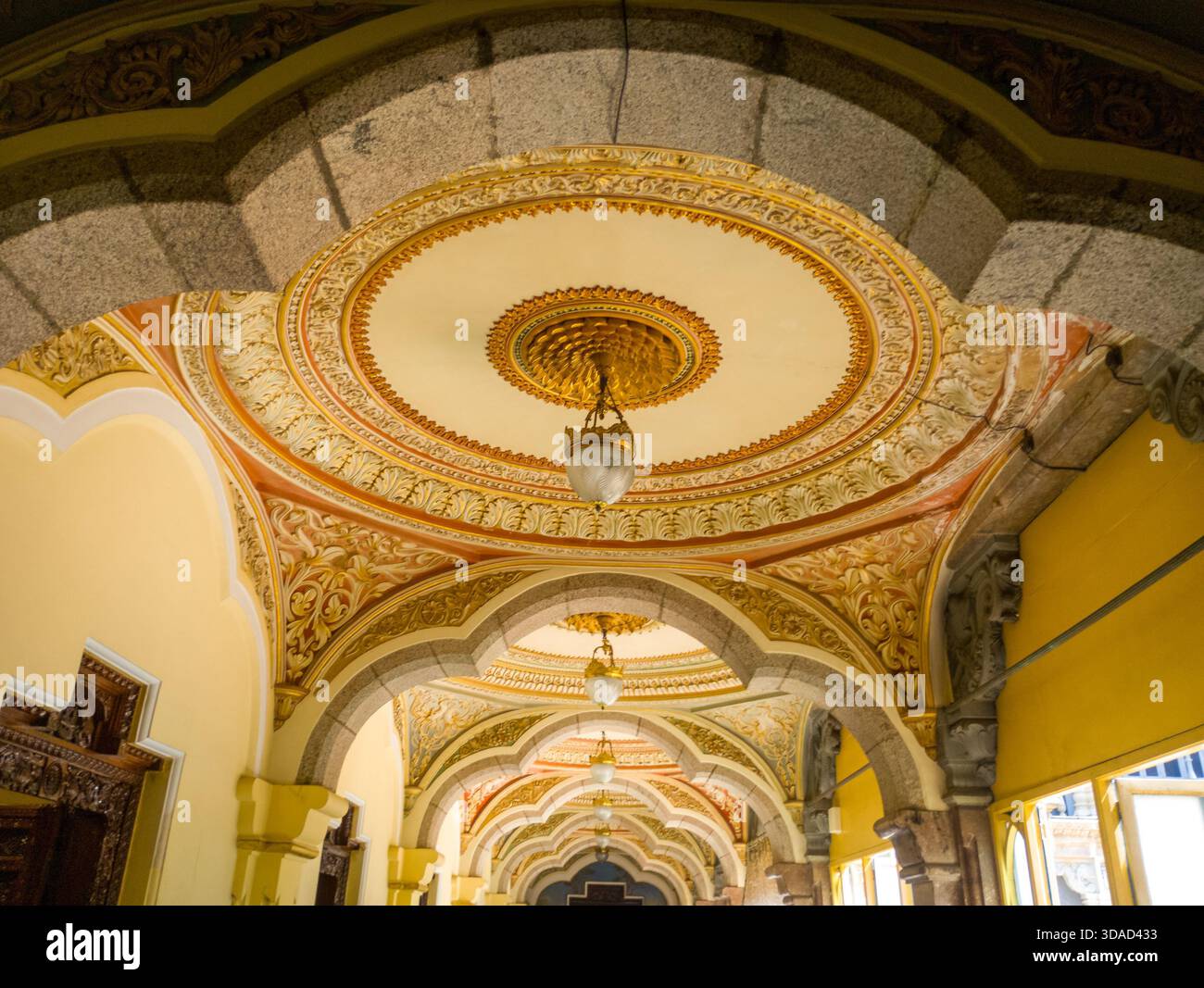 Arcata decorata sul soffitto con affreschi e lampade sospese, corridoio giallo dall'architettura tradizionale Foto Stock