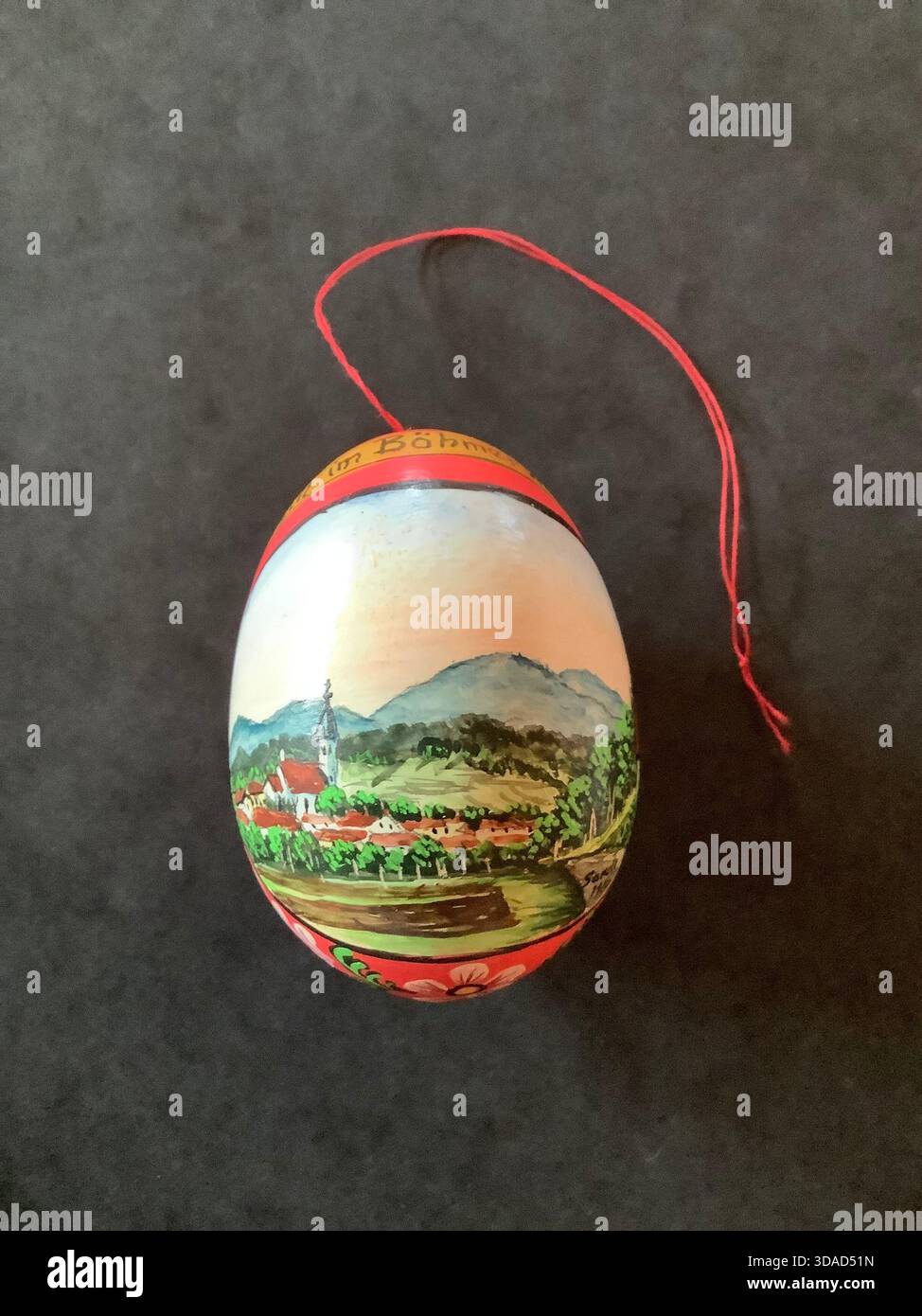 Si tratta di un tradizionale uovo di Pasqua ceco dipinto a mano con un tranquillo paesaggio della foresta boema caratterizzato da una chiesa del villaggio e colline ondulate. Foto Stock