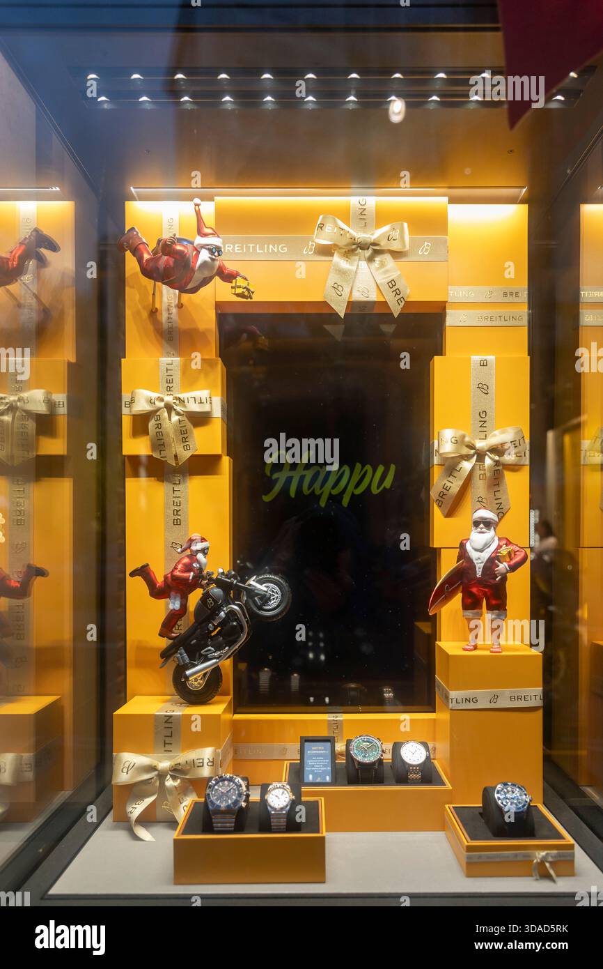 Londra, Regno Unito, 7 dicembre 2025, Una divertente vetrina natalizia per un marchio di orologi con personaggi di babbo natale che navigano, cavalcano una moto e volano, Foto Stock