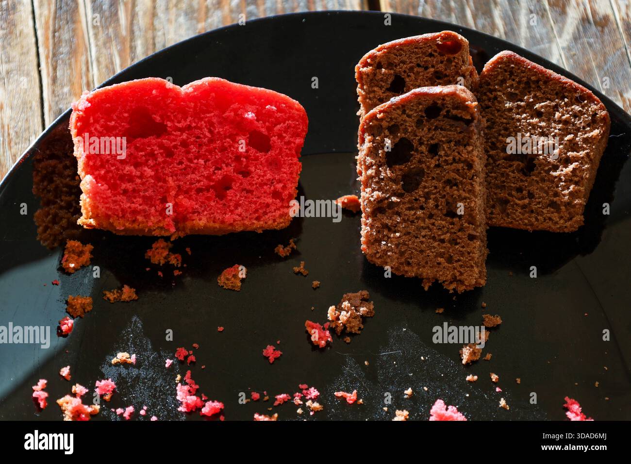 Fette di torta al cioccolato e alla fragola sul piatto nero Foto Stock