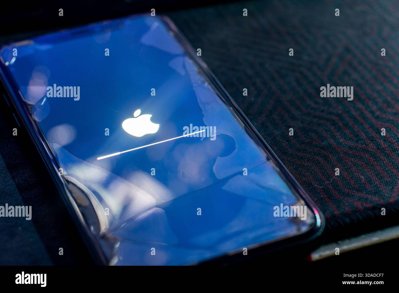 Bajawa, Indonesia - 9 dicembre 2025: Concetto di un vecchio iPhone 11 che riceve ancora l'ultimo aggiornamento software iOS, visualizzato con una schermata incrinata. Foto Stock