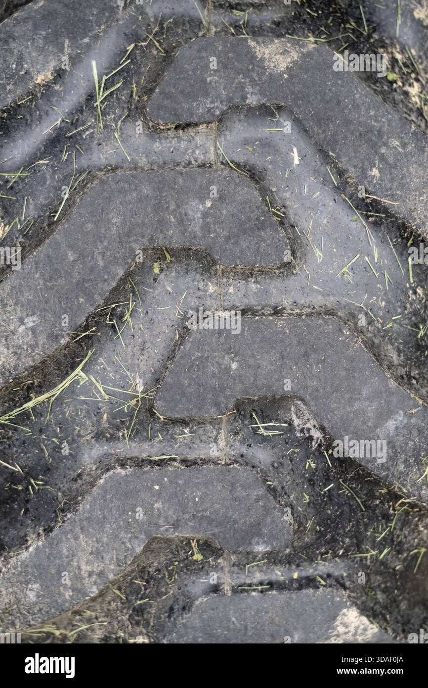 Primo piano dello pneumatico del trattore con l'erba Foto Stock