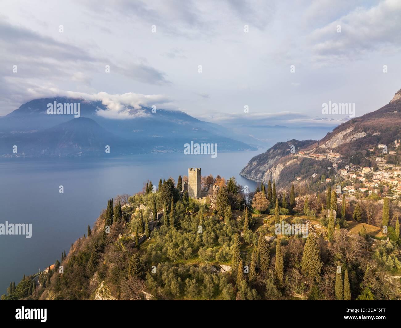 Vista aerea del Castello di Vezio, alto tra alberi verdeggianti, che si affaccia sulle serene acque blu del Lago di Como, Varenna, Lombardia, Italia. Foto Stock