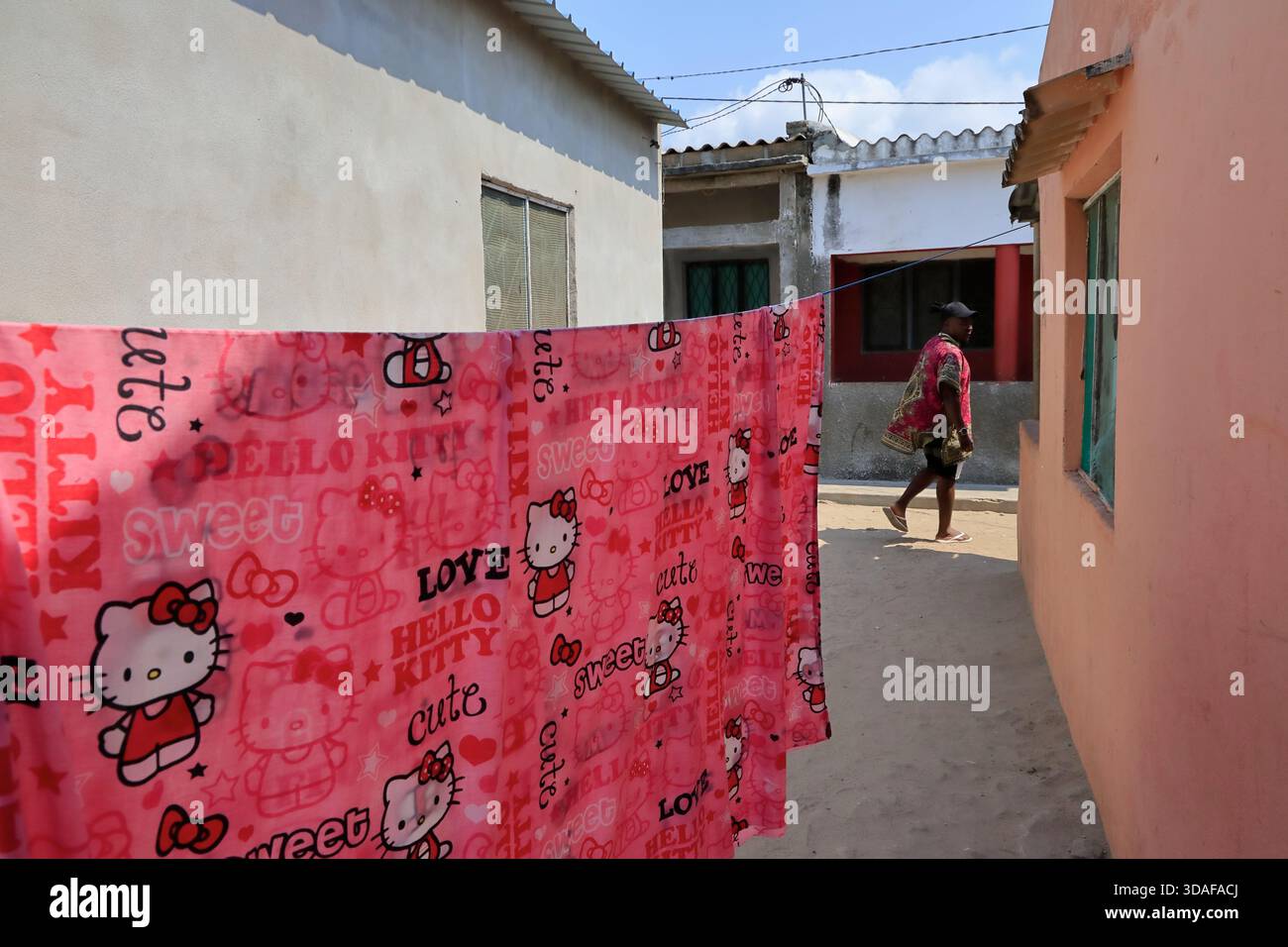 Un lenzuolo rosso con il logo Hello Kitty appeso fuori da una casa a Macuti, sull'isola del Mozambico, Mozambico Foto Stock