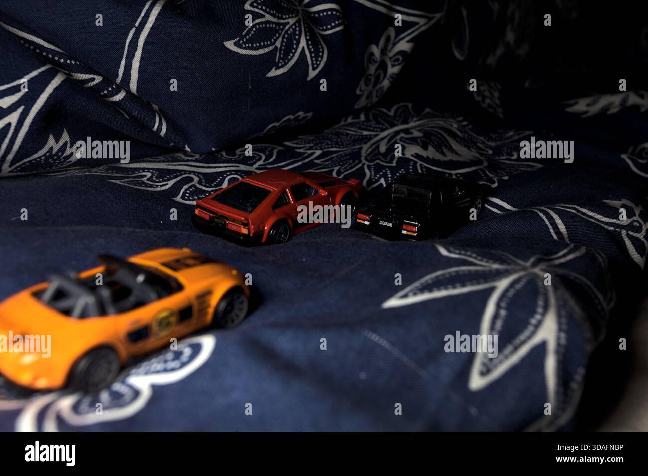 Genova, Italia - 14 NOVEMBRE 2025 - repliche Hot Wheels e Matchbox di una Mazda MX-5 Miata 2015 arancione, una Toyota Corolla 1982 rossa e una 1984 T nera Foto Stock
