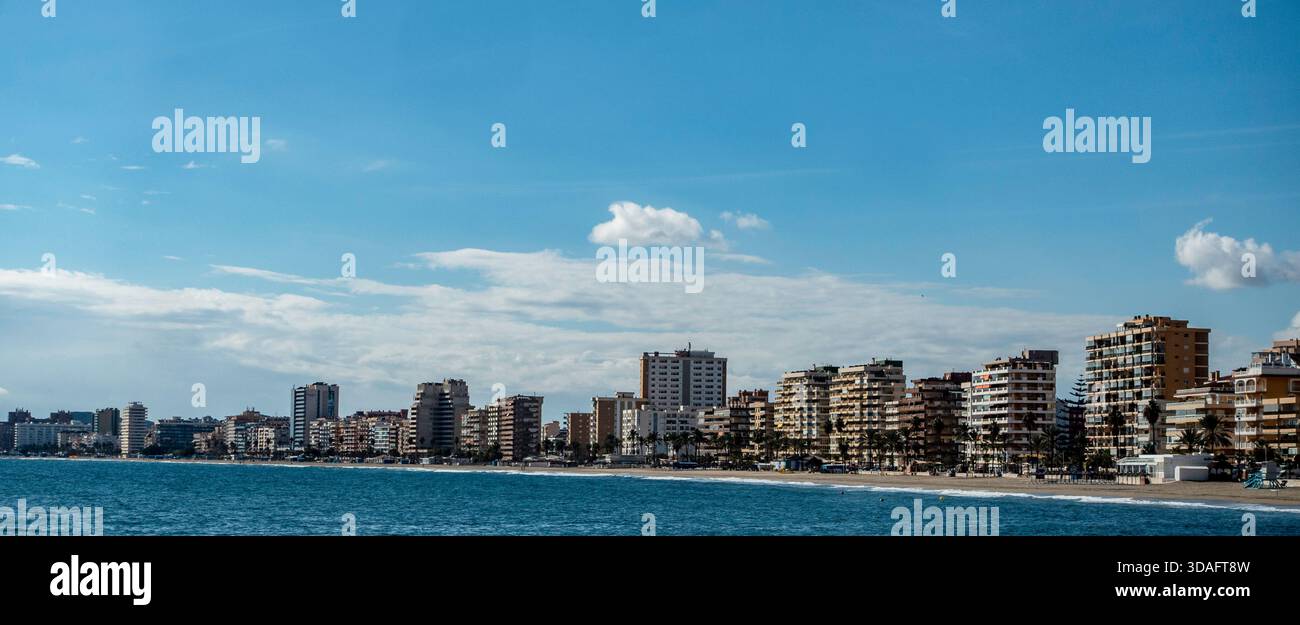 Skyline di edifici residenziali alti lungo la spiaggia di Fuengirola, Spagna. Vista dal Mar Mediterraneo, con un cielo blu e nuvole sparse. Foto Stock