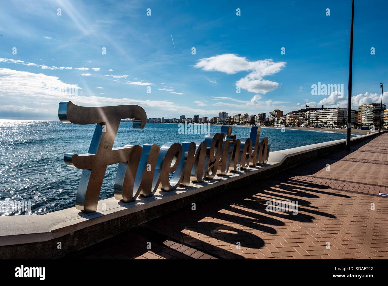 Grande cartello color argento "Fuengirola" sul lungomare. Fuengirola, Spagna, Mar Mediterraneo, grattacieli in lontananza. Giorno di sole, lungo Foto Stock