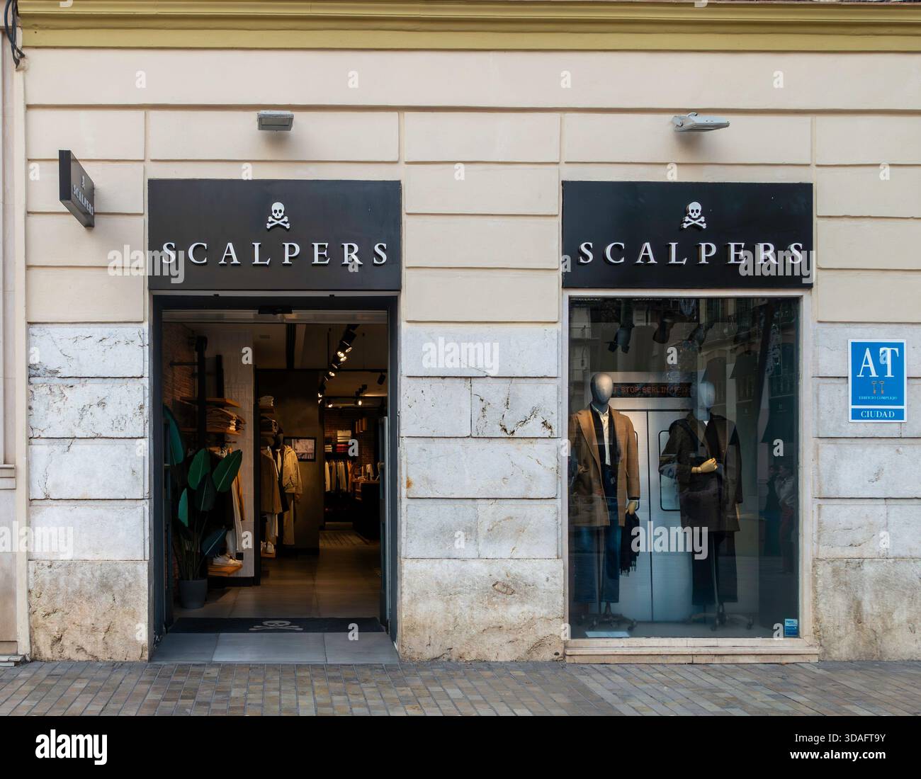 Negozio di abbigliamento in scala con logo teschio, Malaga, Spagna. La moda maschile è esposta su manichini e pavimentazioni piastrellate. Negozio boutique. Foto Stock