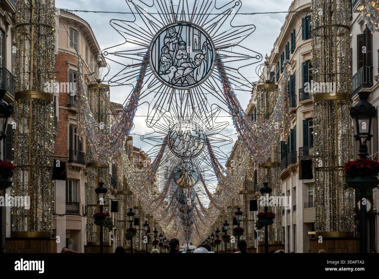 Decorazioni natalizie su una strada pedonale per lo shopping a Malaga, Spagna. Intricati motivi religiosi sono appesi tra gli edifici di appartamenti storici Foto Stock
