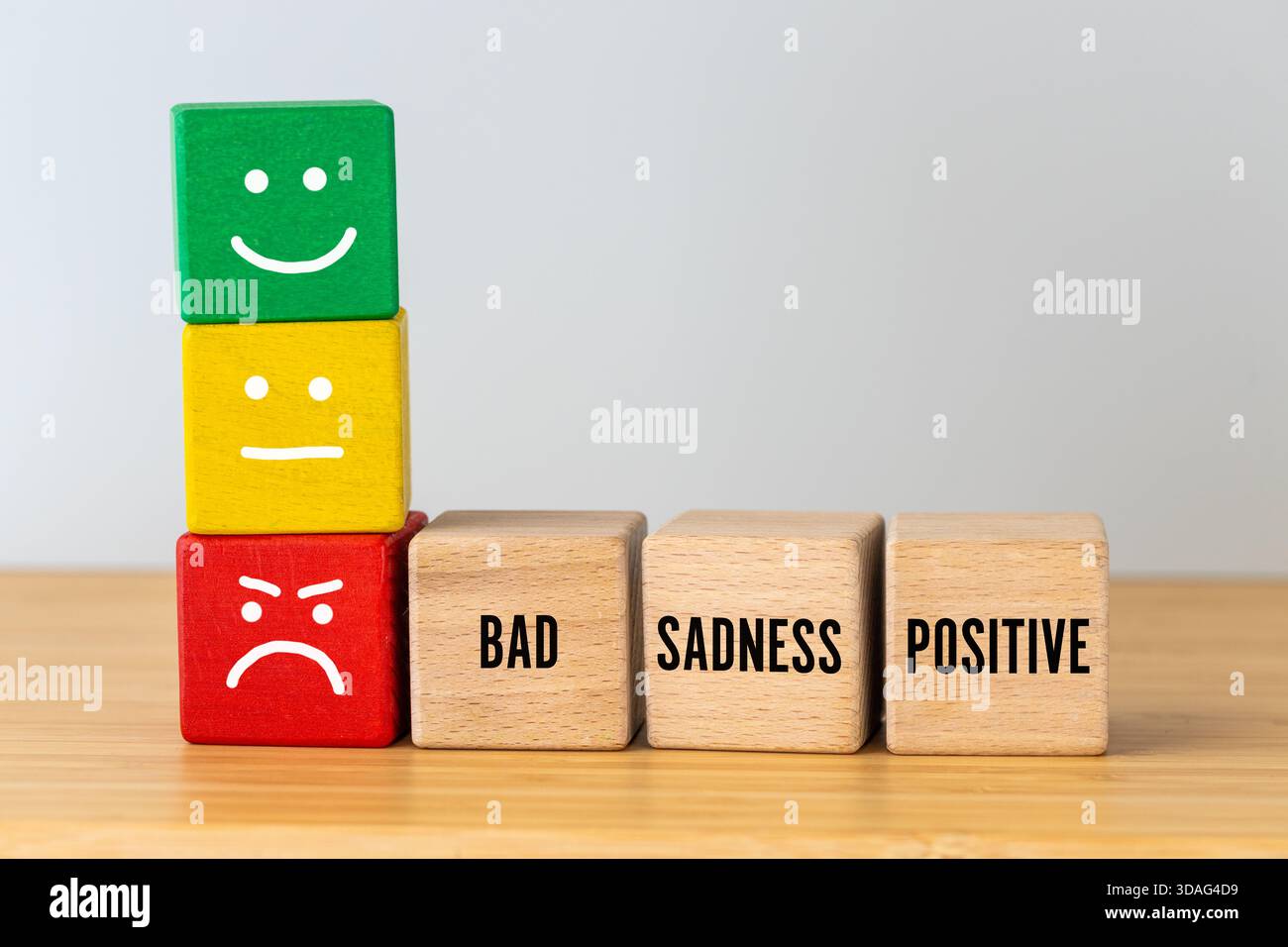 Sentimenti emotivi, rabbia, tristezza e gioia. Concetto di indagine sulle emozioni e la soddisfazione. Blocchi di legno con un sorriso, un'espressione normale e un Foto Stock
