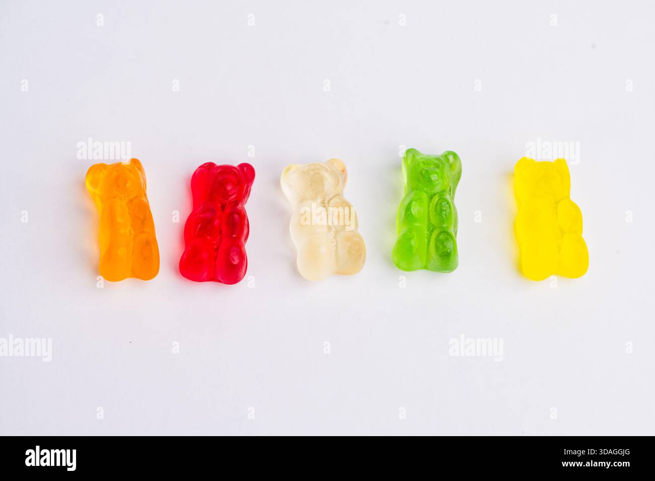 Orsi gommosi di vari colori disposti in linea retta Foto Stock