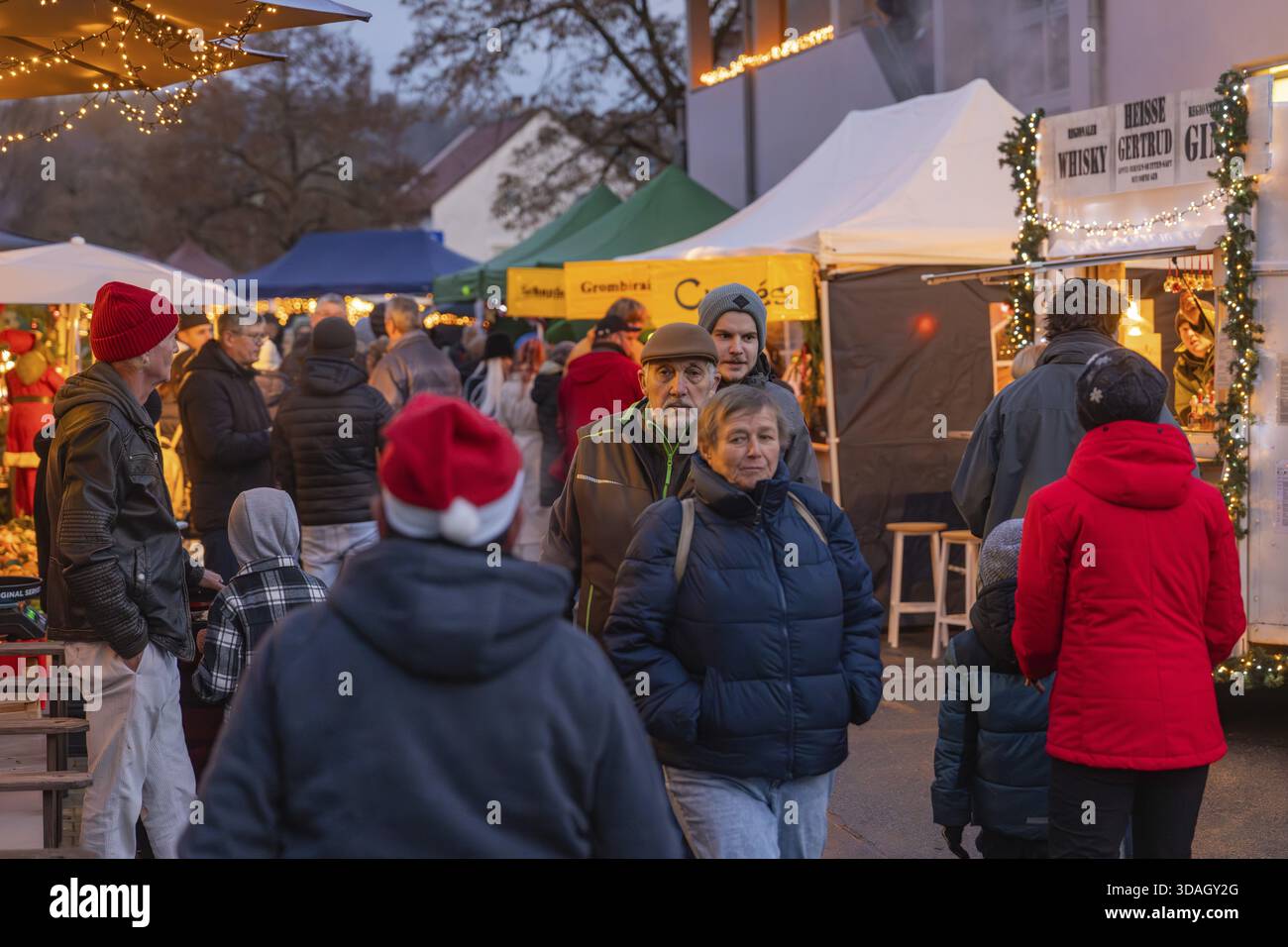 Folla felice in un mercato illuminato in atmosfera natalizia, mercato di Natale di Aidlingen, quartiere di Boeblingen, Germania Foto Stock