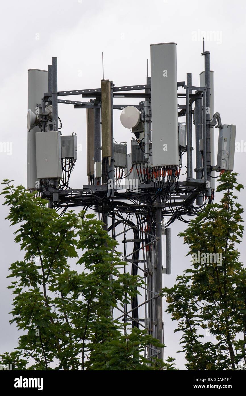 Una torre di telecomunicazioni 5G contro un cielo nuvoloso. Foto Stock