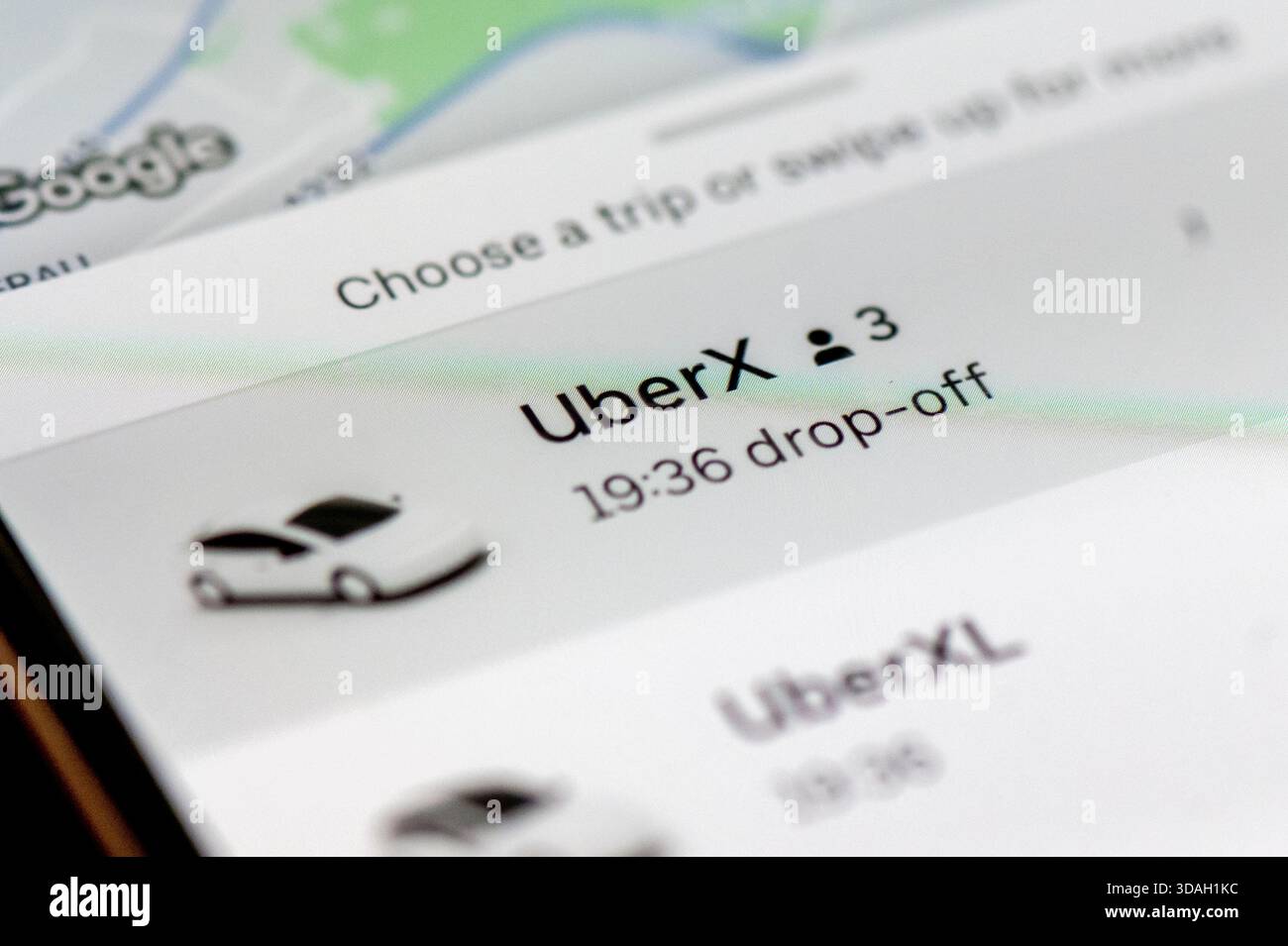 Uno smartphone visualizza l'interfaccia dell'app Uber, che mostra le opzioni per la selezione della corsa, tra cui UberX e UberXL. Foto Stock