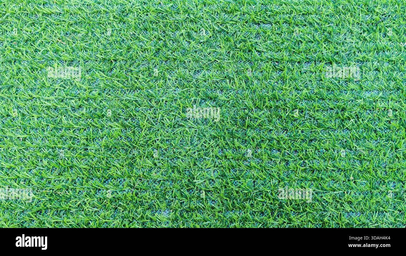 Sfondo artificiale in erba perfettamente curato: Verde vibrante struttura di erba sintetica per lo sport e il paesaggio Foto Stock