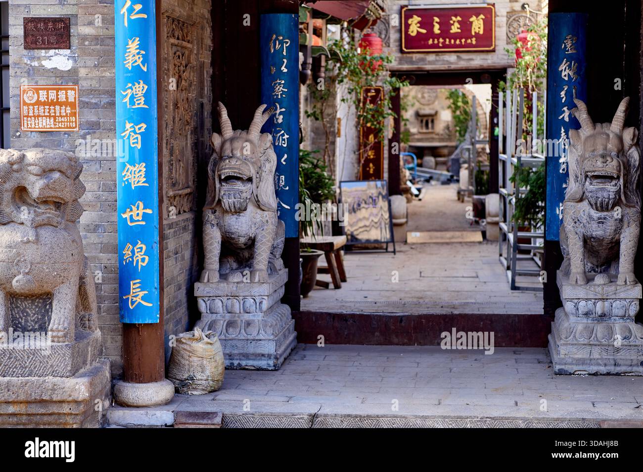 Scena di strada con bestie mitiche che sorvegliano l'ingresso di una casa nell'antica città di Datong in Cina Foto Stock