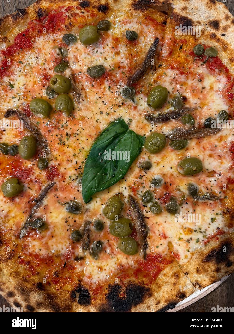 Pizza Napoli con foglia di basilico al centro - Immagine stock catturata con smartphone