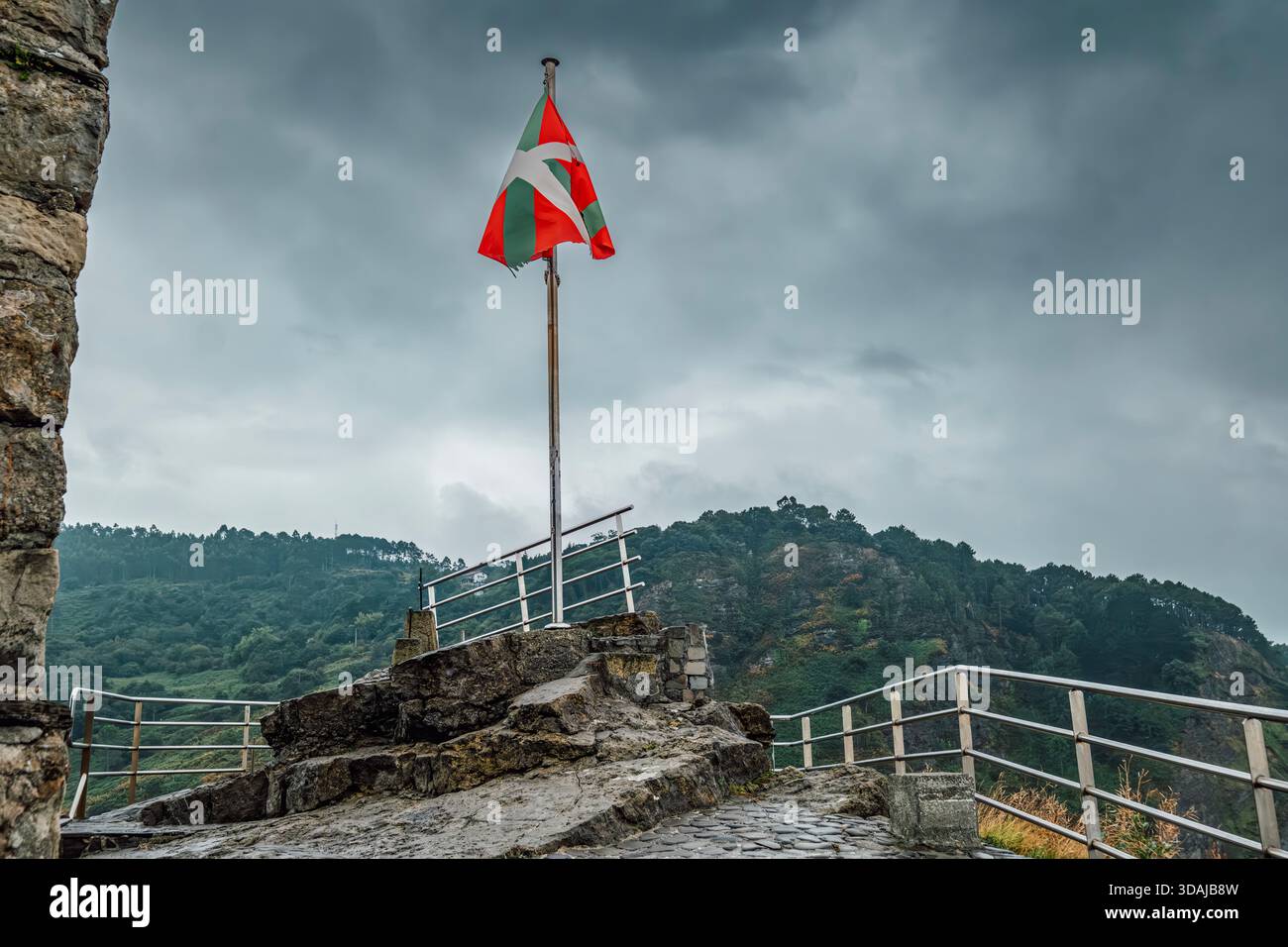 Bandiera basca Ikurrina che sventola su San Juan de Gaztelugatxe, Spagna Foto Stock