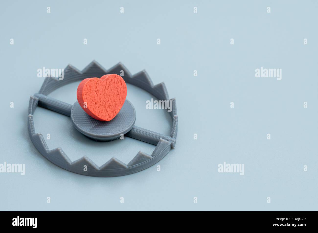 Un cuore rosso è inserito in una trappola per orsi. Tradimento, rottura del cuore, rischio di relazione, trappola d'amore, concetto di relazioni tossiche. Foto Stock