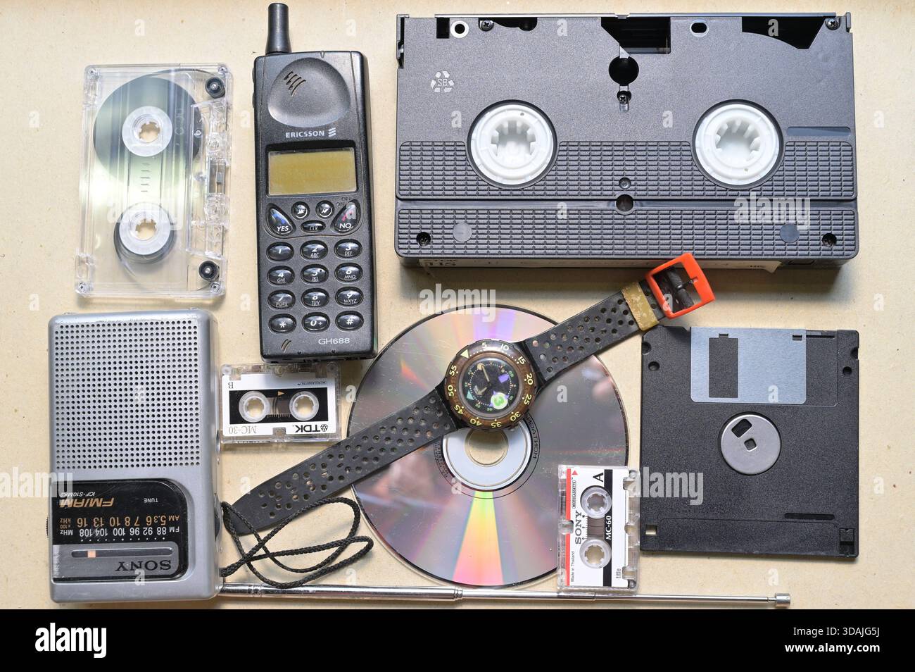 Il nostalgico assortimento di tecnologie vintage e formati multimediali degli anni '1980 e '1990 include telefoni cellulari e microcassette audio VHS Foto Stock