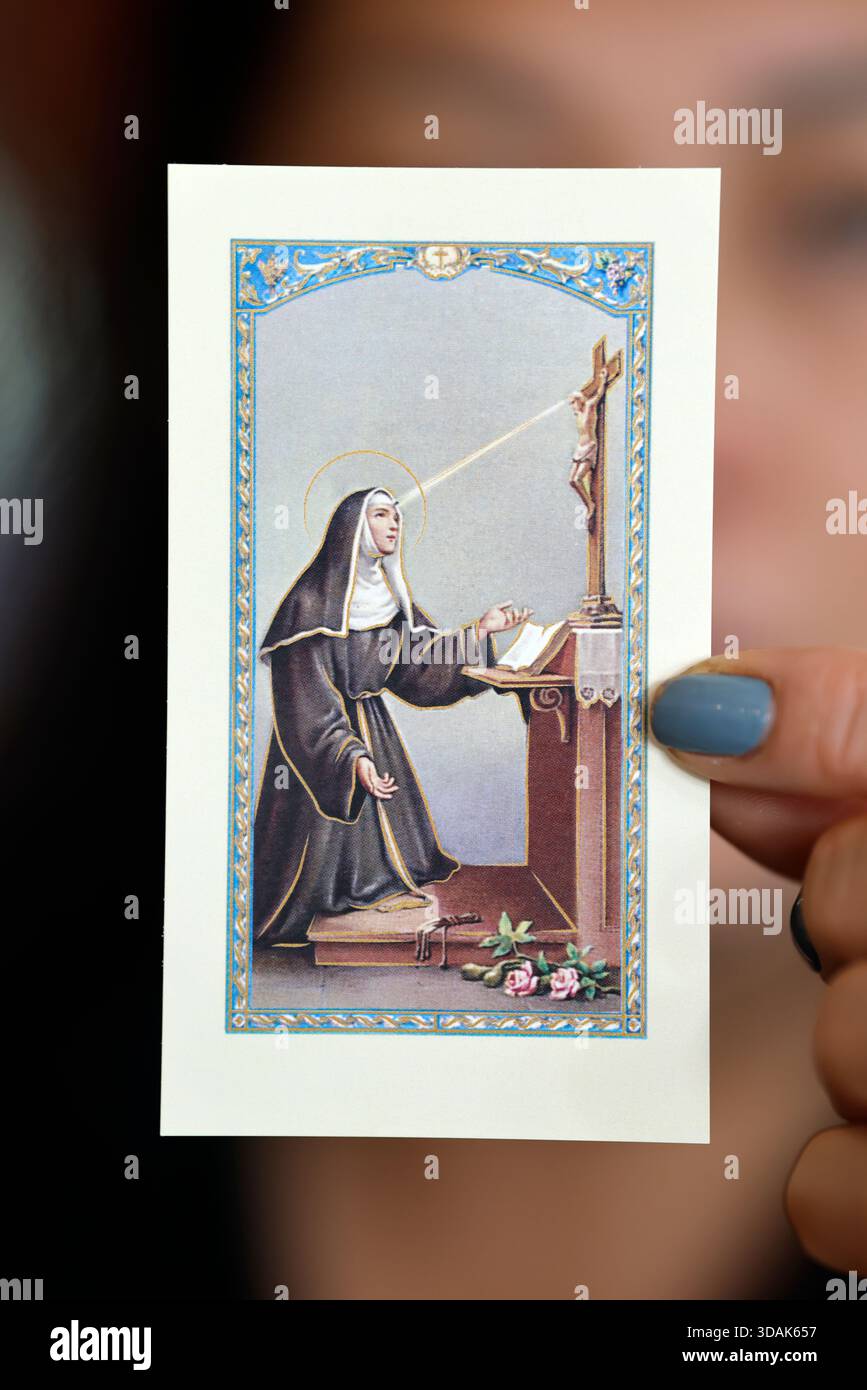 Fede e spiritualità. Donna cattolica con un'immagine religiosa in mano. Santa Rita di Cascia è la patrona delle vittime di abusi, delle coppie e del marr Foto Stock