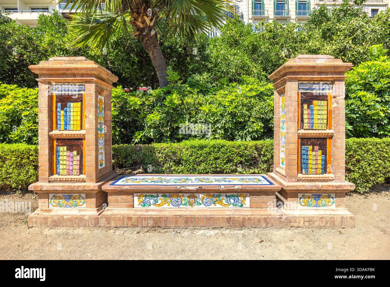 Malaga, Spagna - 11 settembre 2024: Panchina decorata in piastrelle in un parco, fiancheggiata da colonne decorative con inserti colorati in piastrelle. Foto Stock