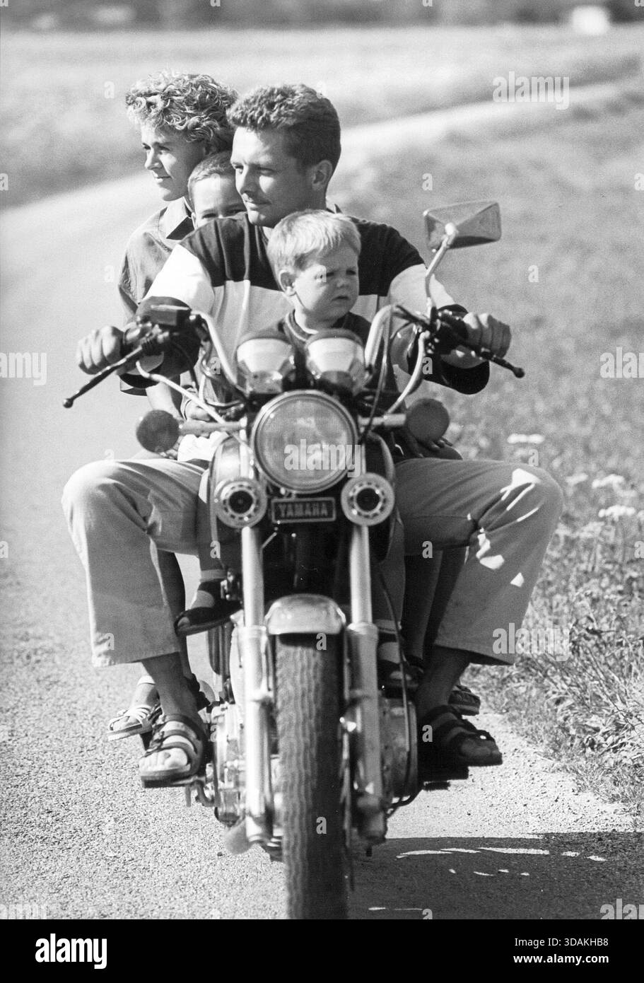 Genitori con i loro figli di due e otto anni in viaggio in moto. [traduzione automatizzata] Foto Stock