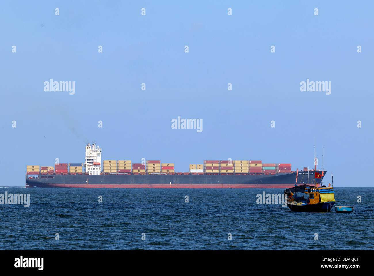 Pescherecci da traino e navi portacontainer giganti. Commercio marittimo e pesca. Vung Tau. Vietnam. Foto Stock