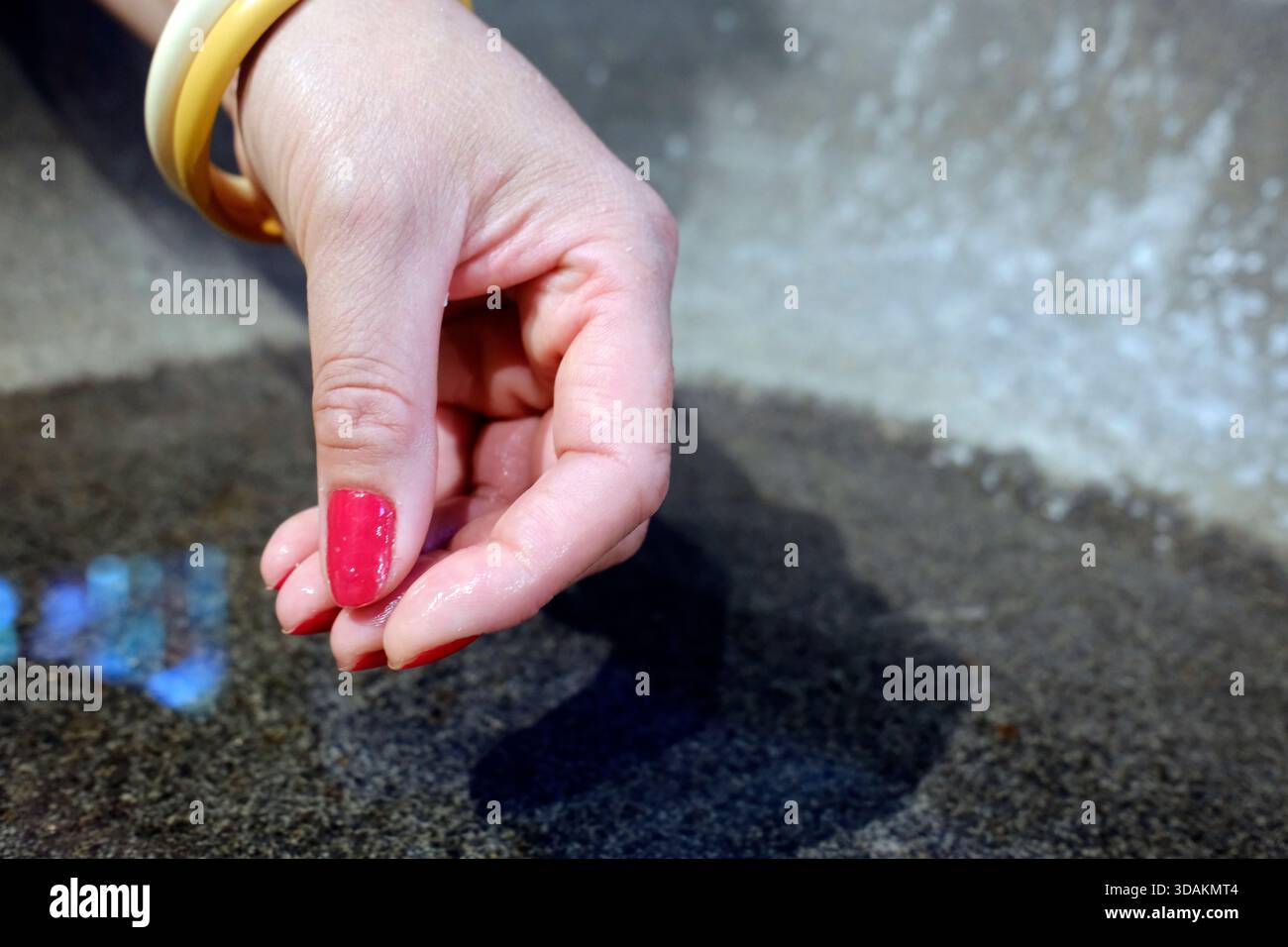 Basilica di Sant'Anna di Auray. Donna che prende l'acqua Santa da una fonte di acqua Santa. Francia. Foto Stock