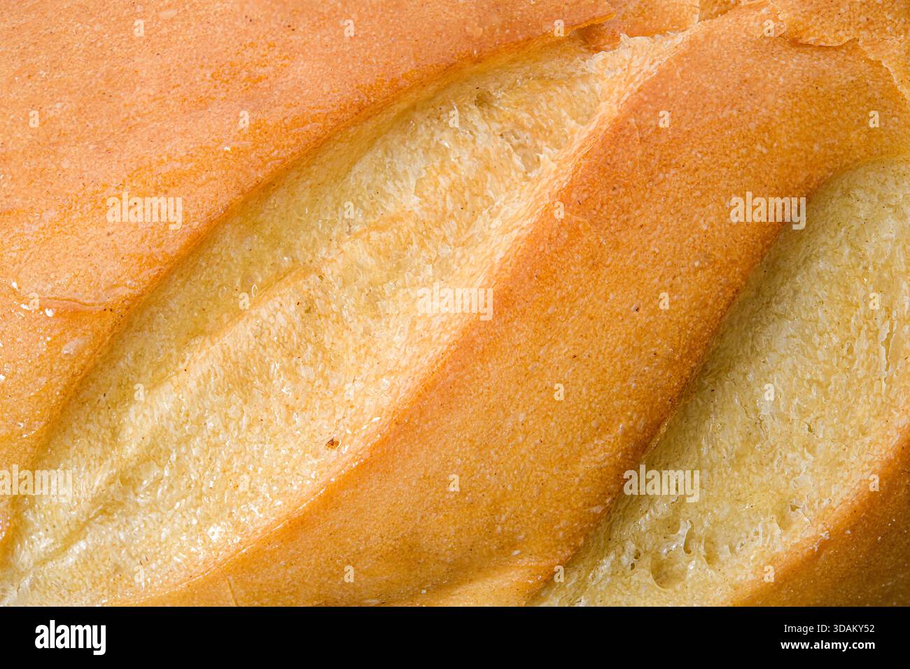 Primo piano della crosta di pane appena sfornata con consistenza dorata. Foto Stock