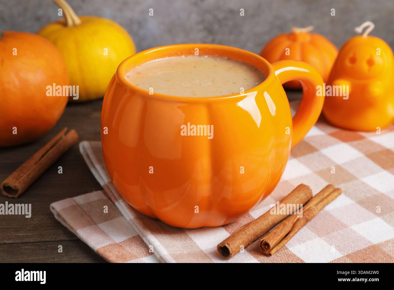 Latte di zucca caldo in tazza su un tavolo di legno, primo piano. Atmosfera autunnale Foto Stock