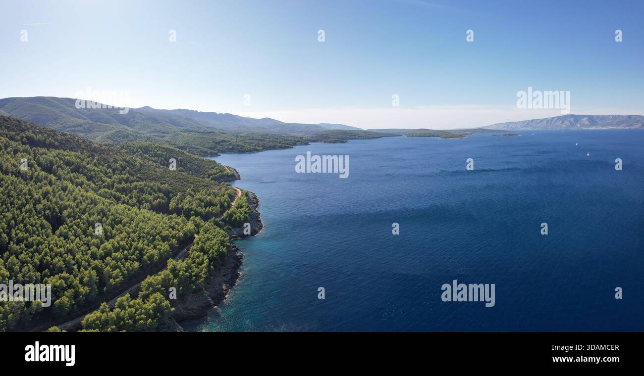 Vista aerea della costa frastagliata dove la fitta foresta verde incontra il mare blu profondo, Jelsa, Spalato-Dalmazia County, Croazia. Foto Stock