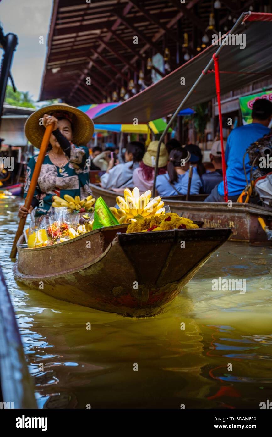 Venditore e la sua barca in un mercato galleggiante. Foto Stock