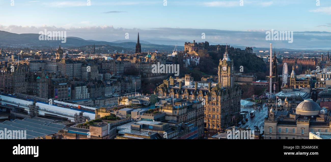 Vista aerea del castello di Edimburgo e della torre dell'orologio Balmoral crogiolati nel bagliore dell'alba, gettando lunghe ombre sulle antiche strade della città, Edimburgo Foto Stock