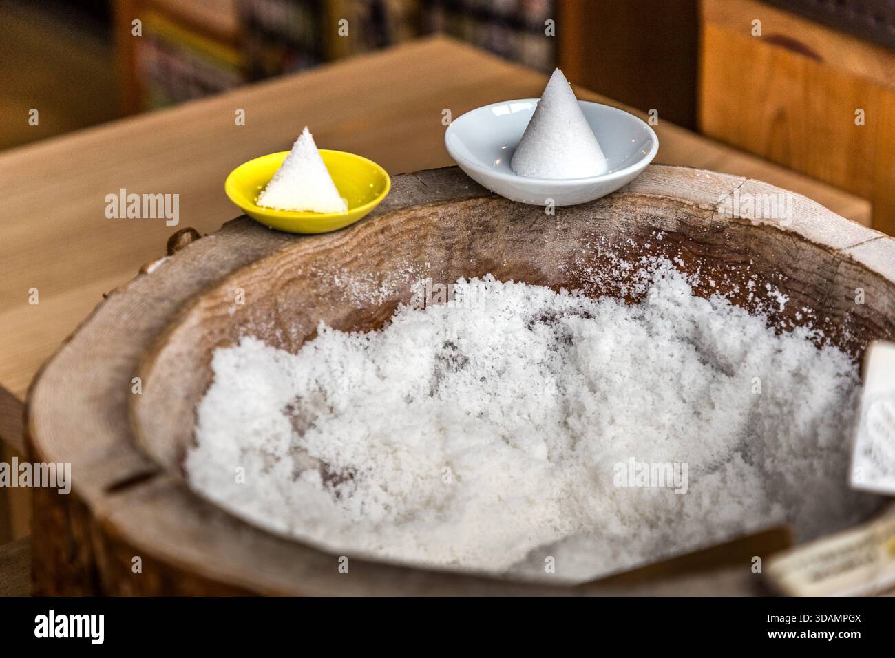 Piccoli coni di sale, chiamati morishio, sono disposti in ciotole su un contenitore di sale in legno a Ise, prefettura di Mie, Giappone. In tutto il Giappone sono considerati un simbolo di purificazione, poiché il sale separa il puro dall'impuro. Foto Stock