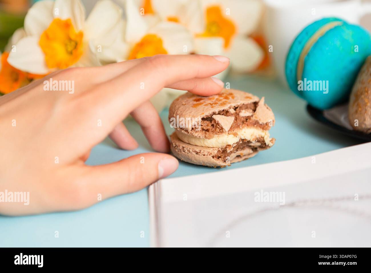 Deliziosa colazione dolce con macaron e caffè su sfondo blu Foto Stock