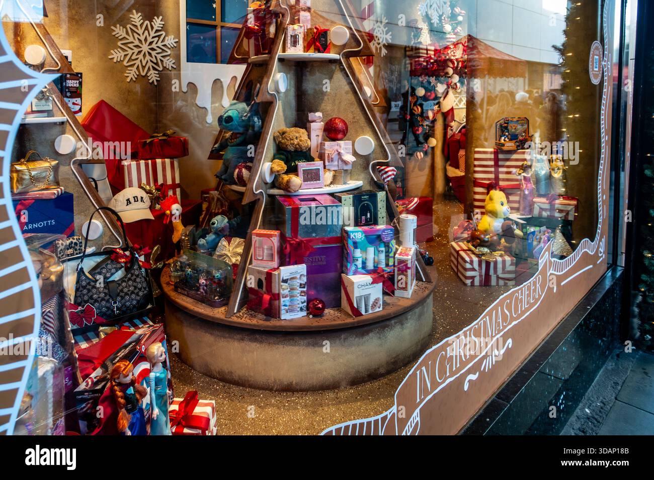 Una vetrina natalizia ad Arnotts, Henry Street, Dublino, con regali, profumi, giocattoli e accessori di lusso su una struttura ad albero stilizzata. Foto Stock
