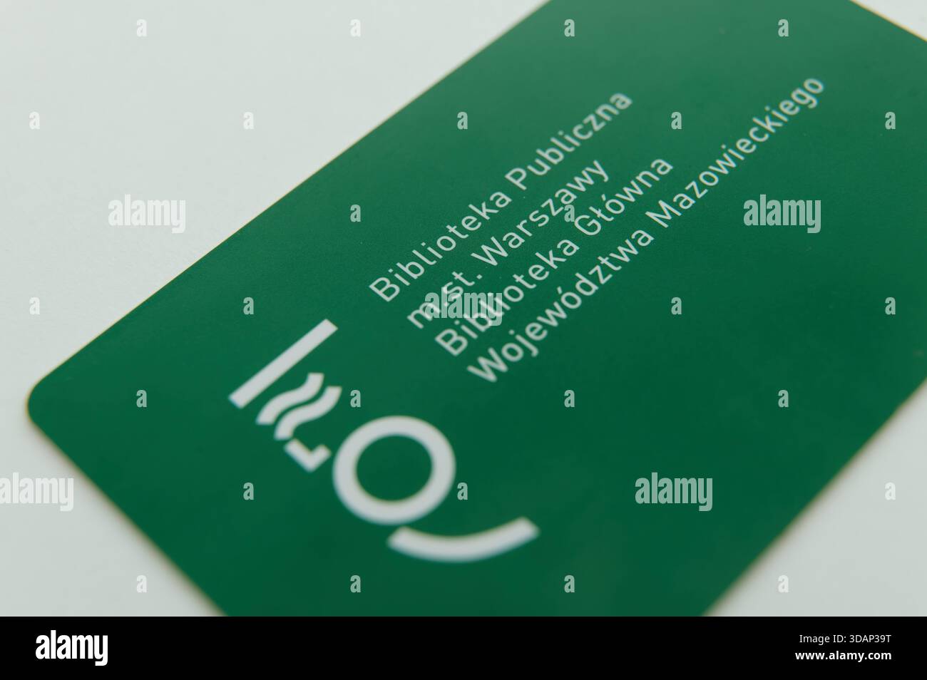 Primo piano di una tessera verde della biblioteca pubblica di Varsavia con testo istituzionale e logo su sfondo bianco. Foto Stock