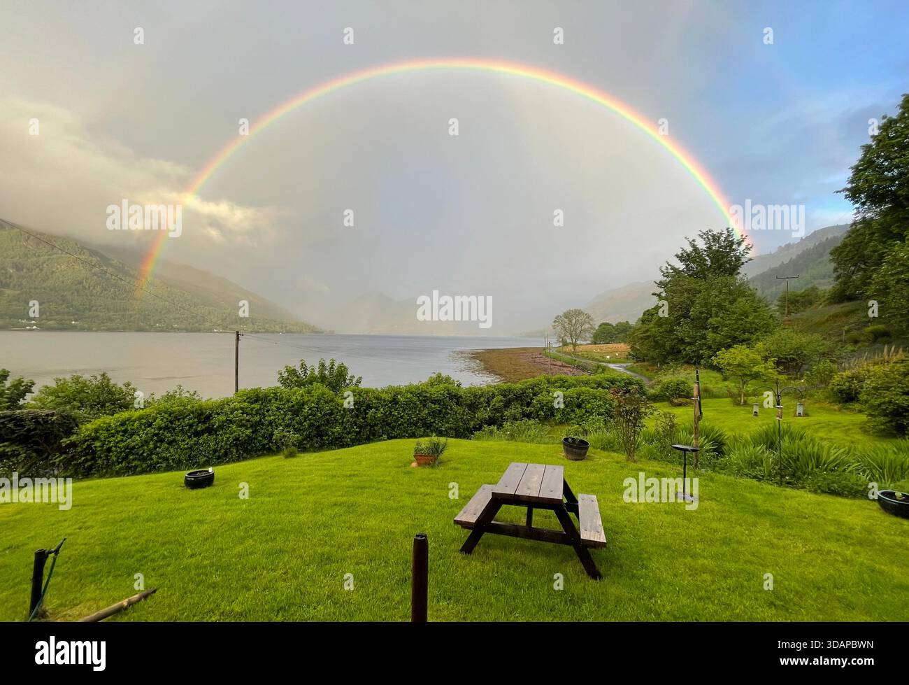 Arcobaleno sul Loch Duich guardando verso le Five Sisters of Kintail, Highlands scozzesi - Immagine stock catturata con smartphone