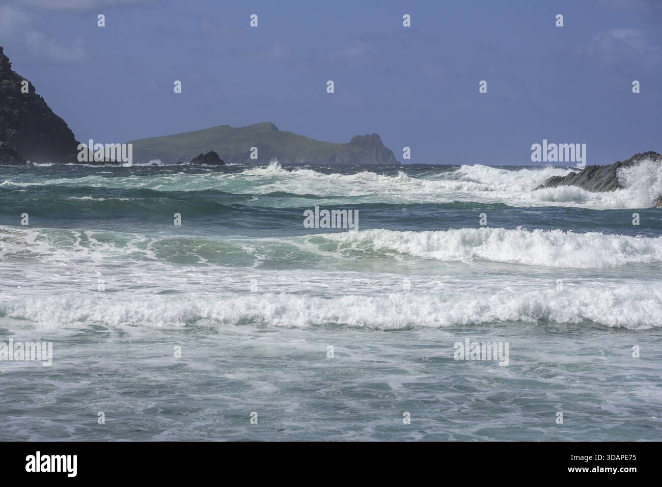 Onde che si infrangono contro le scogliere sullo sfondo Inishtooskert Island (Sleeping Giant), Clogher Strand, Dunurlin, Kerry, Irlanda Foto Stock