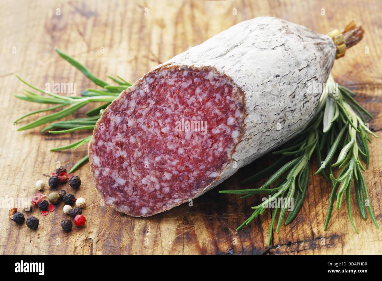 Cibo, Un pezzo di salame su Uno sfondo di legno Foto Stock