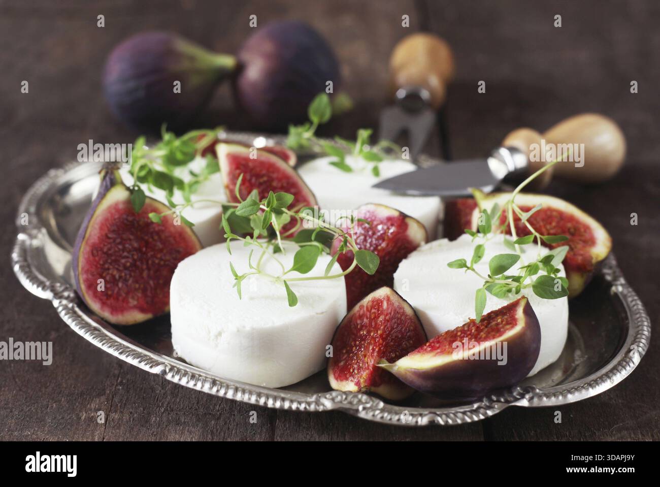 Cibo, fichi e formaggio di capra su Una piastra di metallo Foto Stock