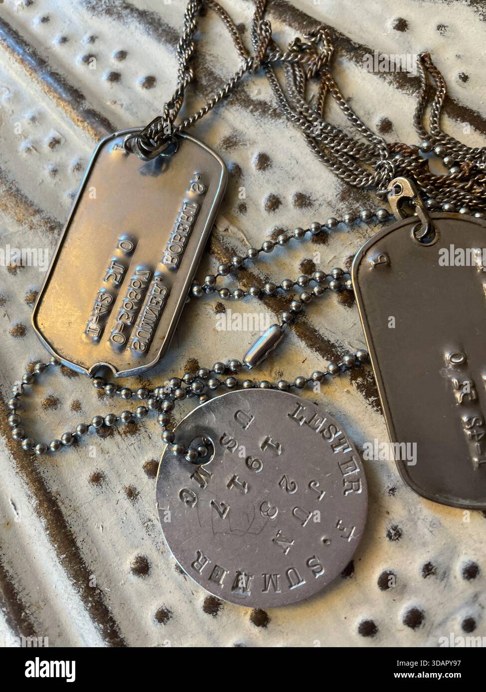 Natura morta di tre generazioni di tag di identificazione militari della stessa famiglia, 2025, Stati Uniti - Immagine stock catturata con smartphone