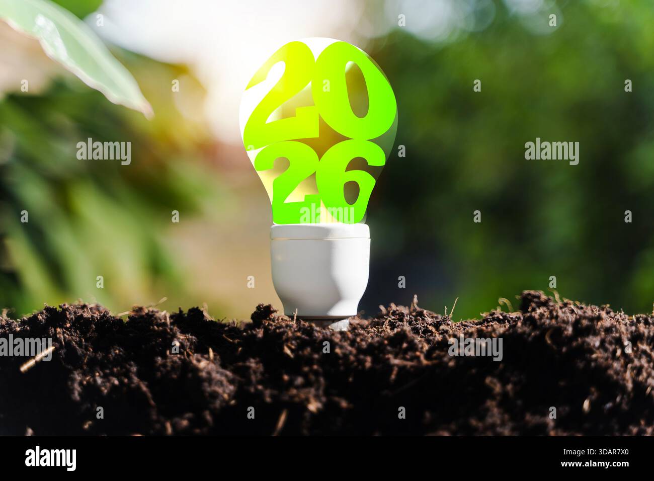 Una lampadina verde 2026 che emerge dal suolo, rappresenta la sostenibilità futura, l'innovazione ecologica, l'energia pulita, gli obiettivi ambientali, e un visio più verde Foto Stock